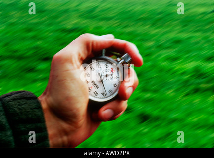 Hand holding a stopwatch and keeping time Stock Photo