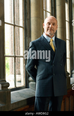 Businessman Standing by Window Stock Photo
