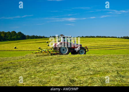 Tractor making hay on the meadows, Bavaria, Germany Stock Photo