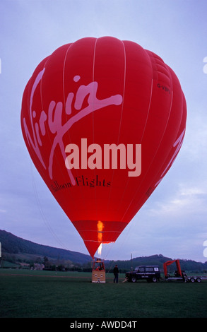 Red balloon preparing to take of for an evening flight Stock Photo
