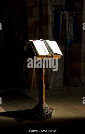 An open bible on a lecturn lit by the suns rays in a church Stock Photo