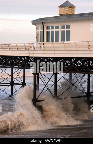 Side view of Cromer pier with crashing waves Stock Photo