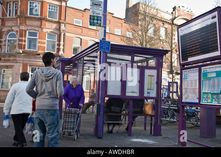 Passengers view an electronic bus time arrival departure board whilst waiting for a bus. Loughborough, Leicestershire, England. Stock Photo