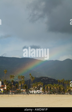 CALIFORNIA Santa Barbara Rainbow and storm clouds over city volleyball nets on beach mountains in background Stock Photo