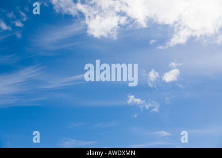 Blue sky with fluffy white cumulus clouds and cirrus mare's tail cloud in clement weather. England UK Britain Stock Photo