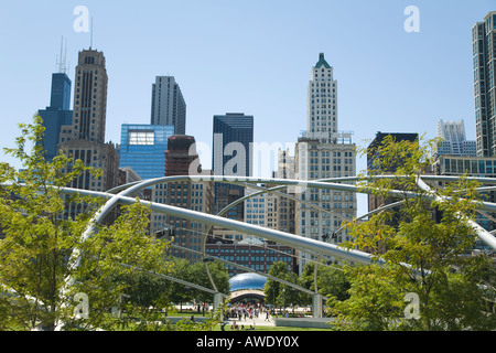 ILLINOIS Chicago The Bean Cloud Gate sculpture Millennium Park viewed from BP bridge trellis over Great Lawn city skyline Stock Photo