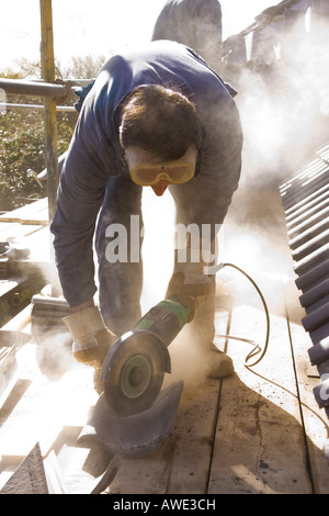 builder cutting roof tiles with an angle grinder Stock Photo