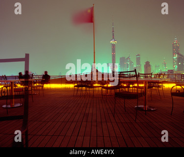 Chinese flag blows in the wind on a balcony in Shanghai, China View from the Bund to Pudong district & Oriental Pearl TV Tower Stock Photo