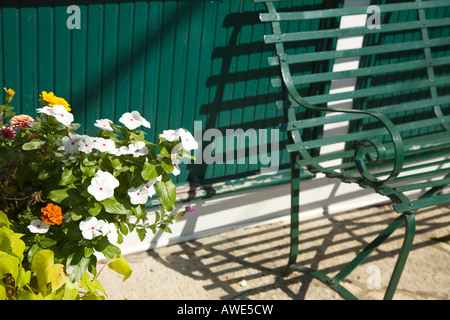 ILLINOIS Long Grove Potted flowers next to green iron bench in quaint shopping district Stock Photo