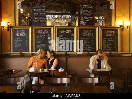 a mixed race couple embracing in a bar Le Progress on Rue des Trois Freres in Montmartre Paris Stock Photo