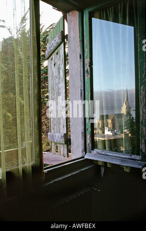 A church is reflected in an open window, Frutillar, Chile Stock Photo