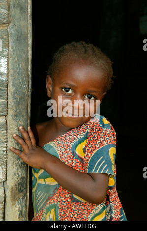 Young girl standing in the front door to her house, Cameroon, Africa Stock Photo