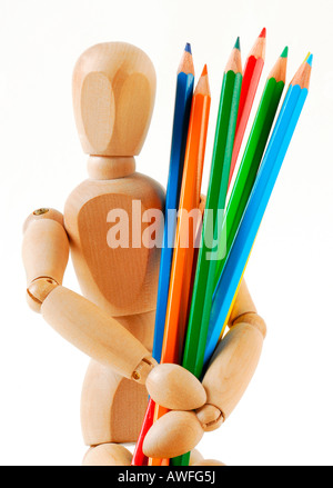 Jointed doll with coloured pencils Stock Photo