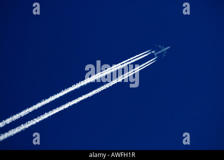 Airplane in a blue sky, contrails (exhaust trail, vapour trail) Stock Photo