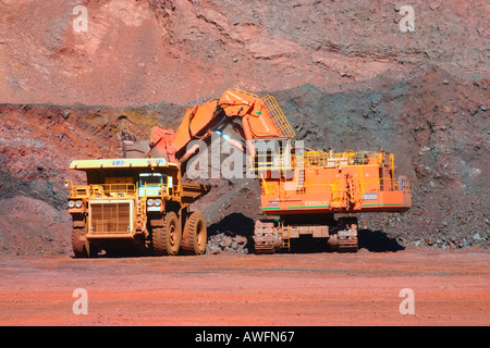 Giant mining equipment in bottom of open cut iron ore mine near Tom Price Western Australia Stock Photo