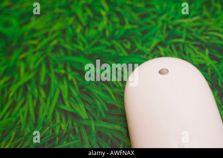 Apple mouse atop mouse pad with grass design Stock Photo