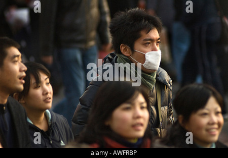 Pollution shrouds a crowd of shoppers in Beijing's Wanfujing shopping district. Stock Photo