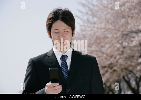 A young man in suit looking at mobile phone Stock Photo