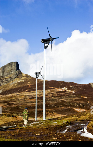 Local man in front of wind turbines on Isle of Eigg Stock Photo