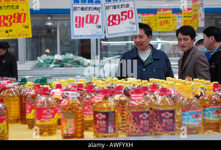 Chinese consumers look at bottle cooking oil in a supermarket in Beijing China. 12 Mar 2008 Stock Photo