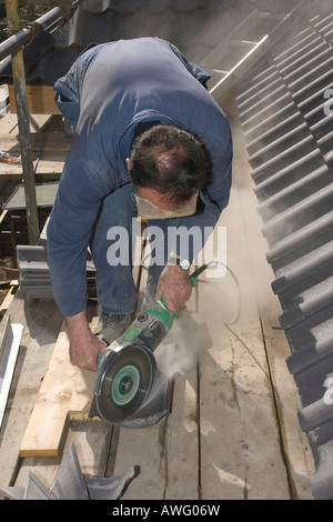builder cutting roof tiles with an angle grinder Stock Photo