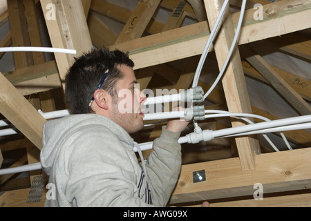 a plumber installing Speedfit polyethylene water pipes in a new house Stock Photo