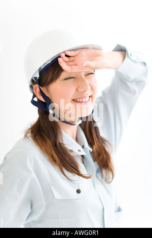 A female construction worker wiping sweat Stock Photo