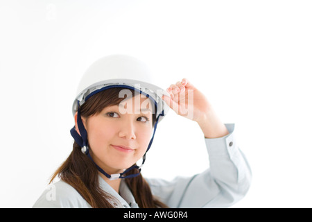 A female construction worker wearing a hardhat Stock Photo