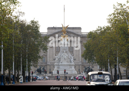 Black London taxi cabs drive down the Mall away from famous Queen Victoria memorial near Buckingham Palace England UK Stock Photo