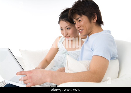 Young couple sitting and looking at laptop computer Stock Photo