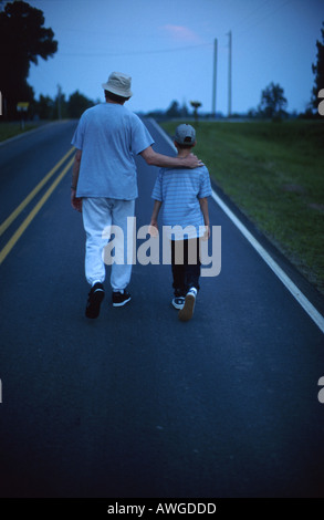 Alabama Baldwin County,Stapleton,boy boys lad lads male kid kids child children,adult adults man men,walking,exercising,country road,visitors travel t Stock Photo