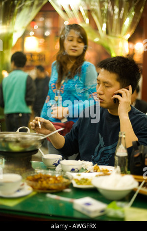A man talks on his mobile in a restaurant, Xian, People's Republic of China Stock Photo