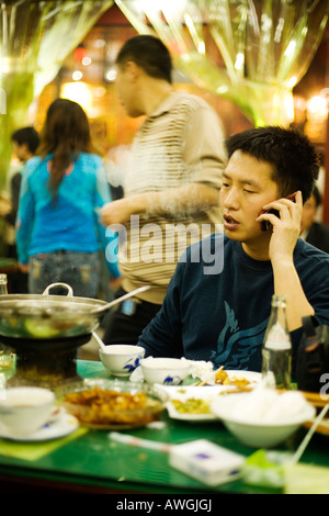 A man talks on his mobile in a restaurant, Xian, People's Republic of China Stock Photo