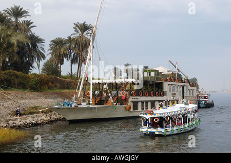 Dahabiyya called Hadeel moored on West Bank at Thebes  with a ferry taking people  back to Luxor on the East Bank Stock Photo