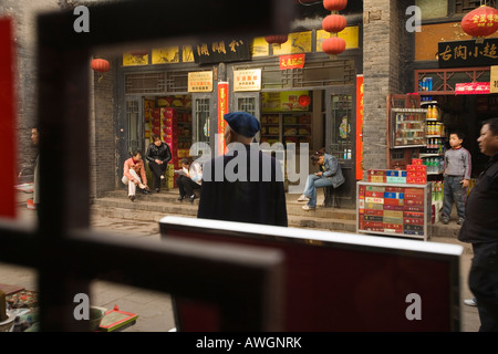 Street life seen through a shop window, Pingyao, People's Republic of China