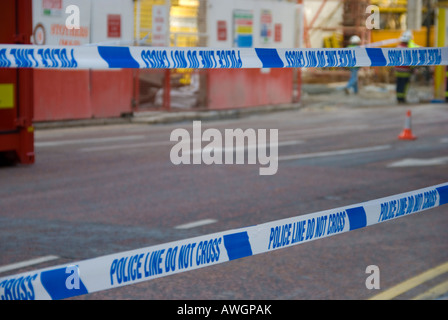 Two pieces of police tape across a road after an incident at a building site. Stock Photo