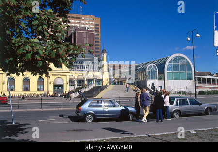 Norway, Oslo Central Station, modern glass and steel main entrance of railway station with group of  people,cars parked Stock Photo