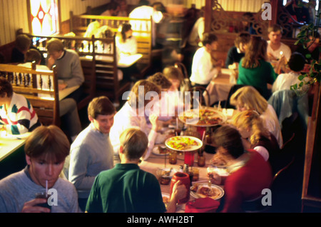 A restaurant scene during the lunch hour. A long exposure shows the motion of these college students as they eat & converse. Stock Photo