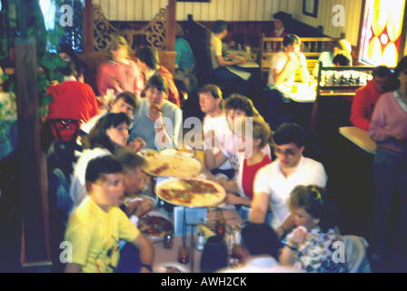 A restaurant scene during the lunch hour. A long exposure shows the motion of these college students as they eat & converse. Stock Photo