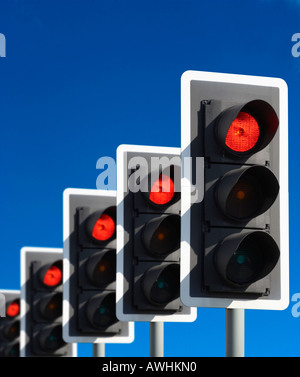 ROW OF FIVE ROAD TRAFFIC LIGHTS SHOWING RED WITH BLUE SKY Stock Photo