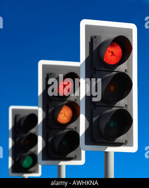 ROW OF THREE ROAD TRAFFIC LIGHTS SHOWING RED AMBER GREEN SEQUENCE WITH BLUE SKY Stock Photo