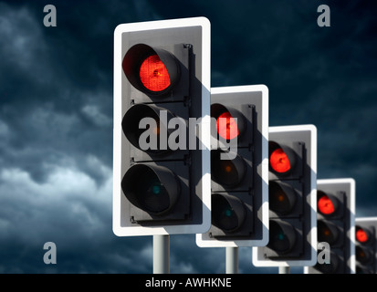 ROW OF FIVE ROAD TRAFFIC LIGHTS SHOWING RED WITH STORMY SKY Stock Photo
