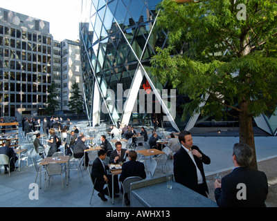 businessmen office workers having lunch lunchtime at the base of the Swiss Reinsurance building a k a the gherkin London UK Stock Photo
