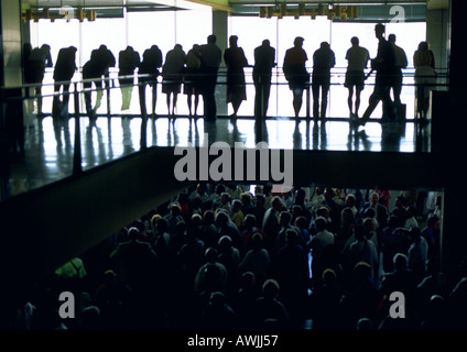 People standing next to balcony watching crowd below Stock Photo