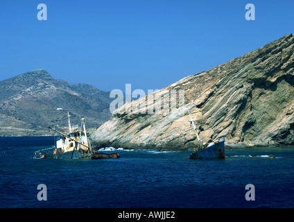 Greece, fishing boats wrecked along rocky coast Stock Photo