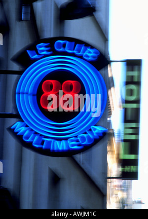 Le Club Multimedia neon sign with 'Hotel' sign in background, blurred Stock Photo