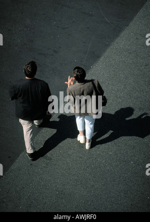 Two people walking on asphalt, high angle view Stock Photo