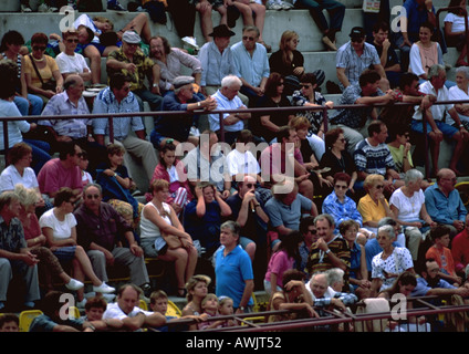 Women spectators sit in the stands, some wearing colorful headscarves ...