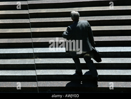 Businessman walking up stairs Stock Photo
