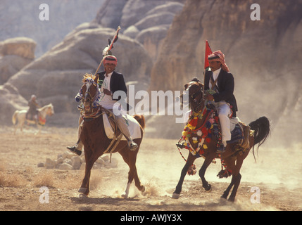 Raising dust as Arab horses and men participate in a horse race in the Jordanian desert, near Petra, Jordan Stock Photo